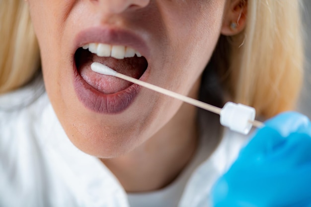 Foto inbrengen van een swab in de mond voor het verzamelen van een speekselmonster voor dna-analyse