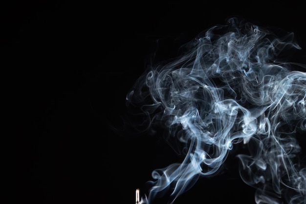 Bastoncino di incenso con fumo su sfondo nero