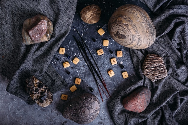 Photo incense sticks among the gloomy and esoteric paraphernalia  runes stones