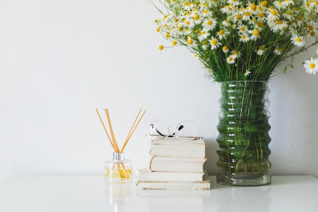 Bastoncini di incenso per la casa dal profumo floreale libro bastoncini di incenso e vaso con fiori di camomilla il concetto di fragranza ecofriendly per la casa terapia termale aromaterapia