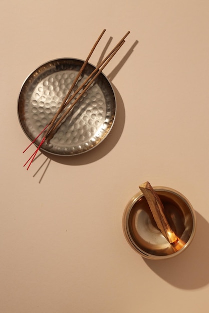 Incense sticks on plate and bowl with wooden chip on white background top view