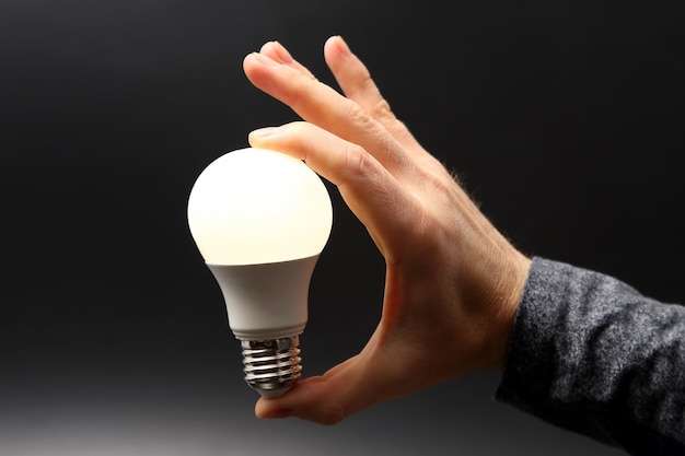 Included led new lamp in human hand on dark space
