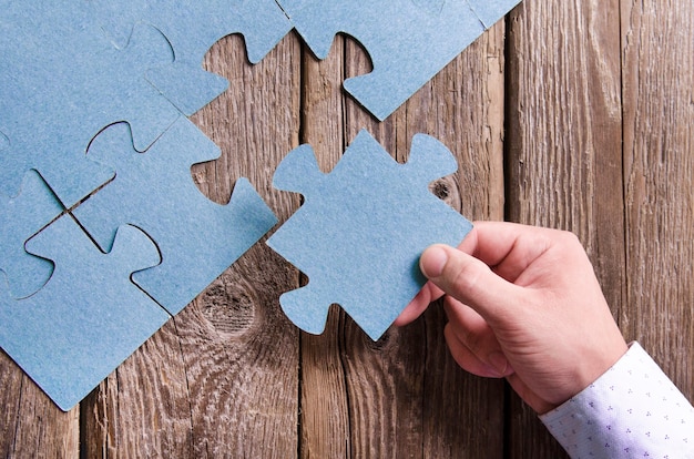 Incomplete puzzles lying on wooden rustic boards.