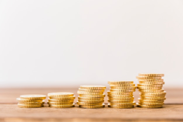 Increasing stacked coins on wooden desk