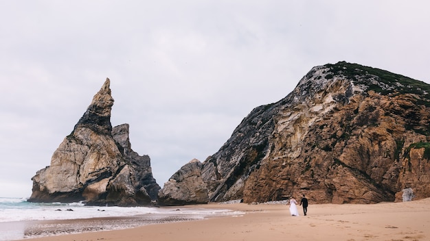 Incredible cliffs on the ocean shore. back view of newlyweds. walk by the sea.