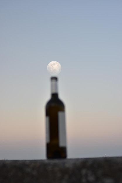 Incredible full moon over the sea and over abandoned bottles on the pier