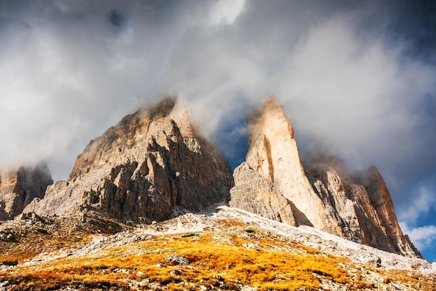 Photo incredible view of the three peaks of lavaredo in morning fog national park tre cime di lavaredo dolomite alps mountains trentino alto adige region sudtirol dolomites italy