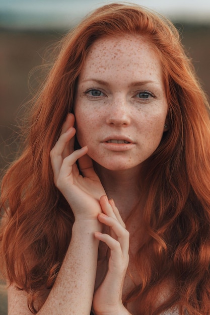 Incredible young woman with long curly hair and freckles face