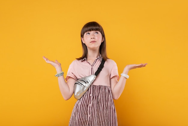 Indefinite. Meditative charming girl wearing lovely clothes and looking at the ceiling