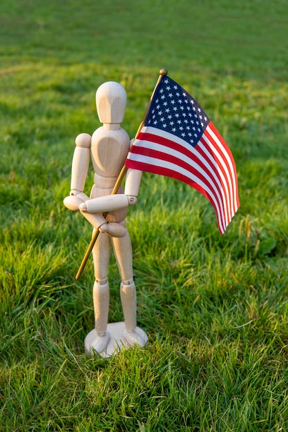 Independence day USA. Veterans day USA. Memorial day concept. Wooden mannequin with American flag