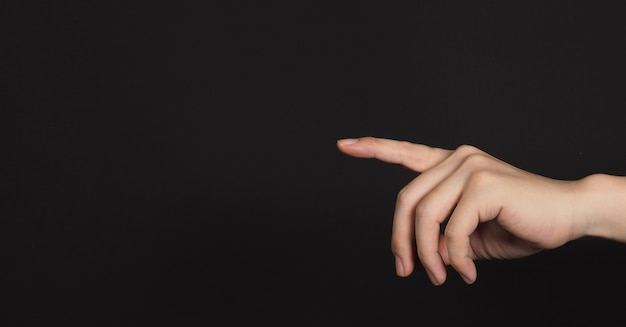 Index finger pointing and isolated on black background.