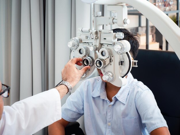 Photo india cute boy sitting in an eyeglass shop with an optometrist specializing in eye disorders and primary eye health looking for a lens to suit his eyesight and get the most effective eyeglassesxa