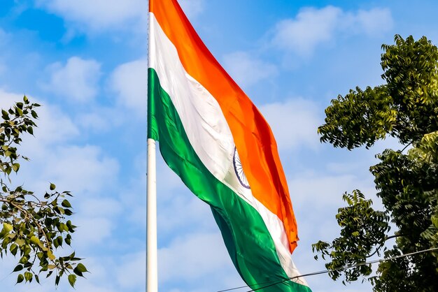 Foto la bandiera dell'india sventola alta a connaught place con orgoglio nel cielo blu. la bandiera indiana sventola.