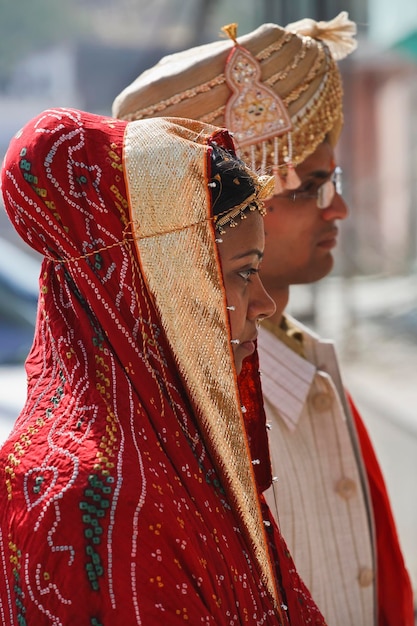 Foto india, rajasthan, jaipur, una sposa indiana sta andando al suo matrimonio con suo marito in costumi tradizionali