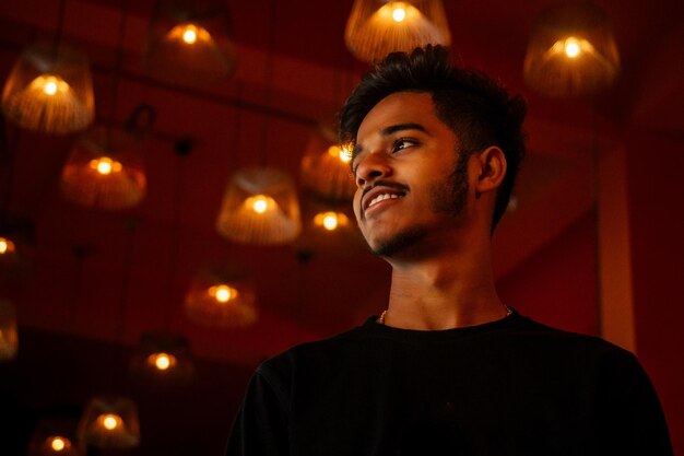 India student stang lighting diyas in dark room