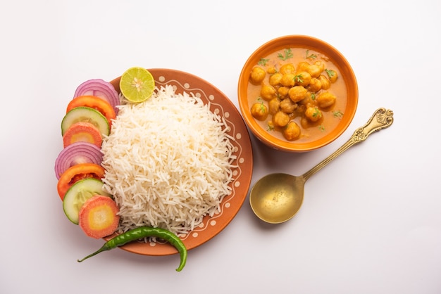 Indiaas eten chole chawal of pittige kikkererwtencurry met gewone rijst geserveerd met groene salade. selectieve focus