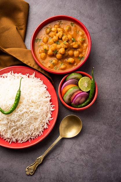 Indiaas eten chole chawal of pittige kikkererwtencurry met gewone rijst geserveerd met groene salade