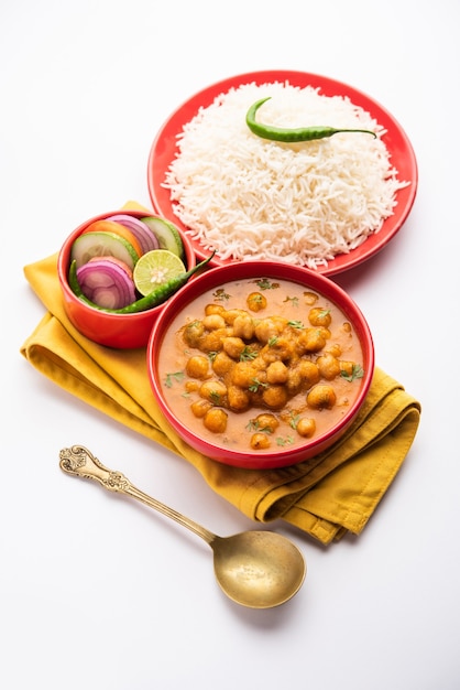 Indiaas eten chole chawal of pittige kikkererwtencurry met gewone rijst geserveerd met groene salade