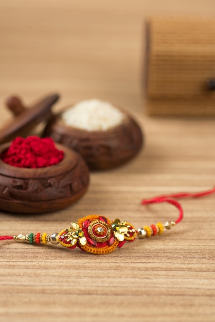 Indiaas festival: Raksha Bandhan-achtergrond met een elegante Rakhi, rijstkorrels en Kumkum