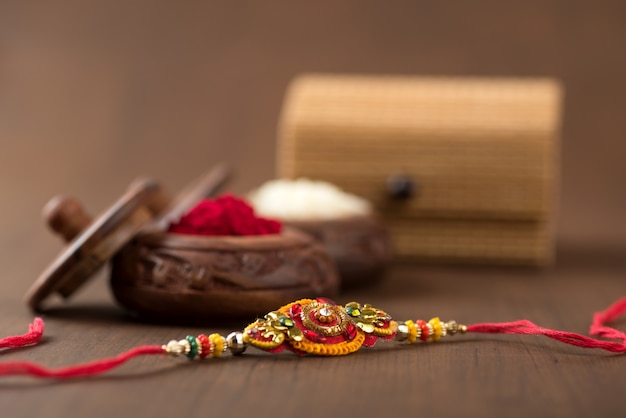 Indiaas festival: Raksha Bandhan-achtergrond met een elegante Rakhi, rijstkorrels en Kumkum