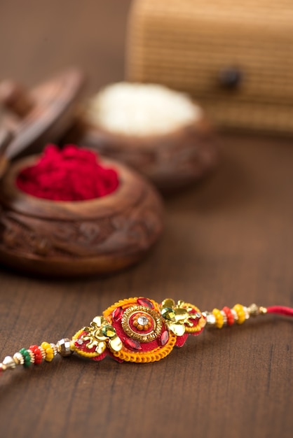 Indiaas festival: Raksha Bandhan-achtergrond met een elegante Rakhi, rijstkorrels en Kumkum