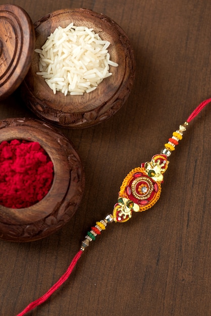 Indiaas festival: Raksha Bandhan-achtergrond met een elegante Rakhi, rijstkorrels en Kumkum