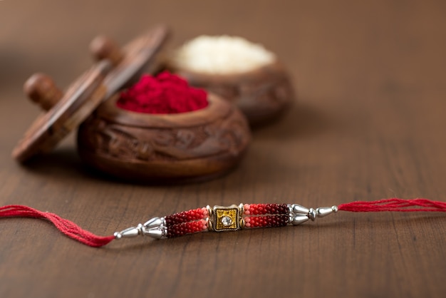 Indiaas festival: Raksha Bandhan-achtergrond met een elegante Rakhi, rijstkorrels en Kumkum