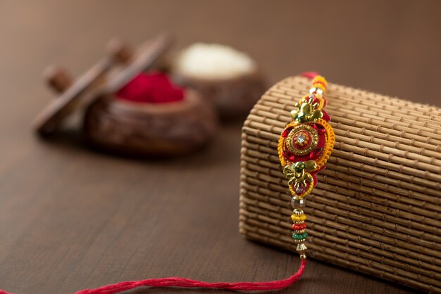 Indiaas festival: Raksha Bandhan-achtergrond met een elegante Rakhi, rijstkorrels en Kumkum