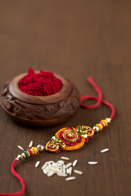 Indiaas festival: Raksha Bandhan-achtergrond met een elegante Rakhi, rijstkorrels en Kumkum