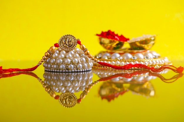 Indiaas festival Raksha Bandhan, Rakhi met rijstkorrels, kumkum op decoratieve plaat, een traditionele Indiase polsband