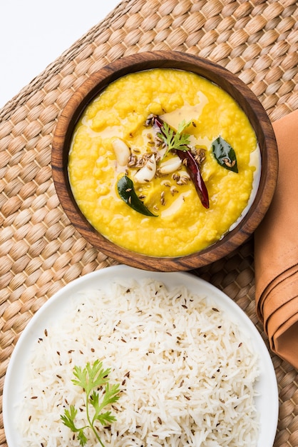 Indiaas populair eten Dal fry of traditionele Dal Tadka Curry geserveerd met jeera rijst, geïsoleerd op witte achtergrond, selectieve focus