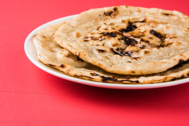 Indiaas speciaal plat brood ook bekend als boter tandoori roti of naan, geserveerd in een wit keramisch kwartbord