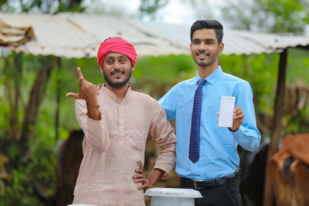 Agronomo indiano che mostra lo schermo dello smartphone con l'agricoltore