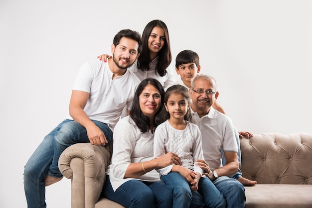 Indian asian family sitting on sofa or couch over white background