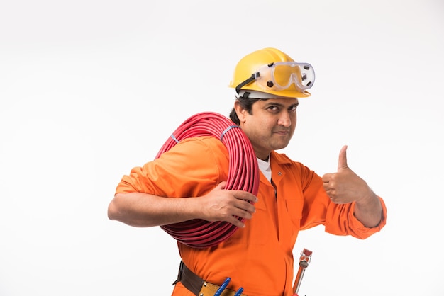 Indian asian handsome electrician or engineer in action with yellow safety hat isolated