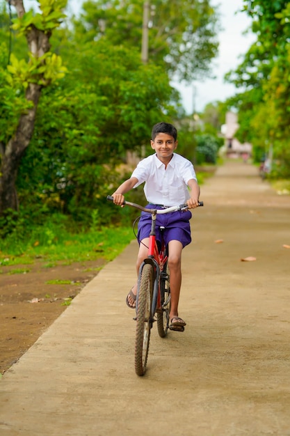 インド/アジアの小さな男の子はサイクルライディングを楽しんでいます