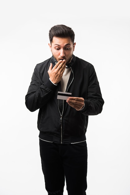 Indian asian man with credit or debit card or electronic plastic swipe card, isolated over white background