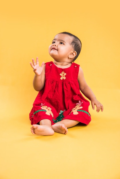 Indian or Asian Toddler, Infant or baby playing with toys or blocks while lying or sitting isolated over bright or colourful background