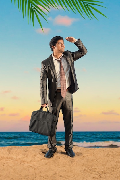 Indian Asian young businessman relaxing or working from beach enjoying break from work