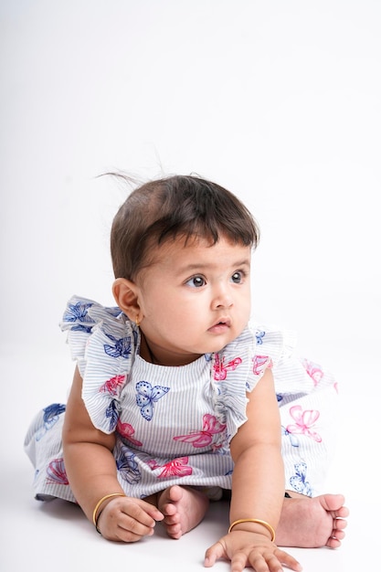 Indian baby girl sitting on white background