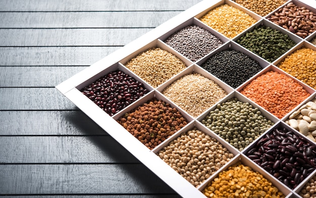 Indian Beans,Pulses,Lentils,Rice and Wheat grain in a white wooden box with cells, selective focus.