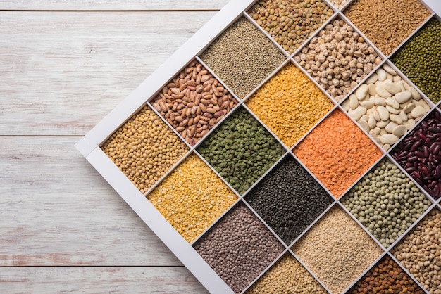 Indian Beans,Pulses,Lentils,Rice and Wheat grain in a white wooden box with cells, selective focus.