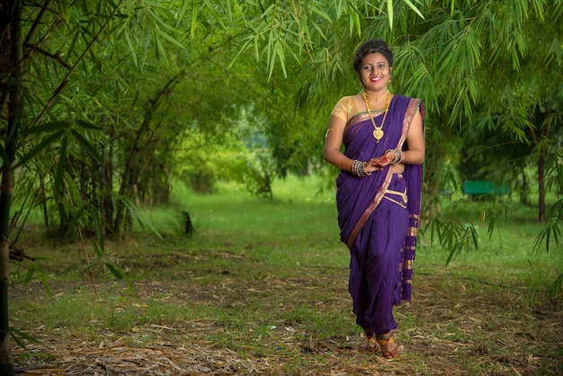 Bella ragazza indiana in saree tradizionale che propone all'aperto