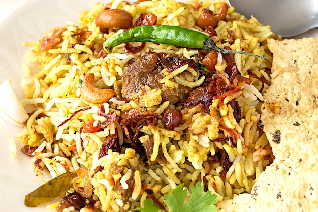 Foto biryani indiano con contorno e peperoncino