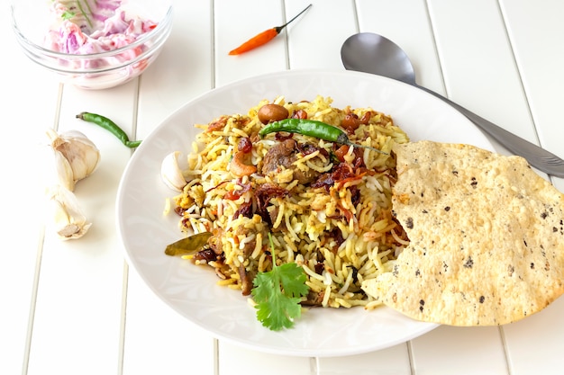 Indian biryani with side dishes, garlics and chilli