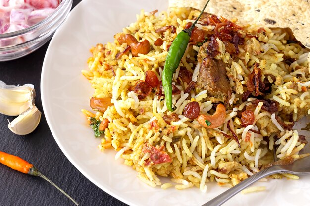 Indian biryani with side dishes, garlics and chilli