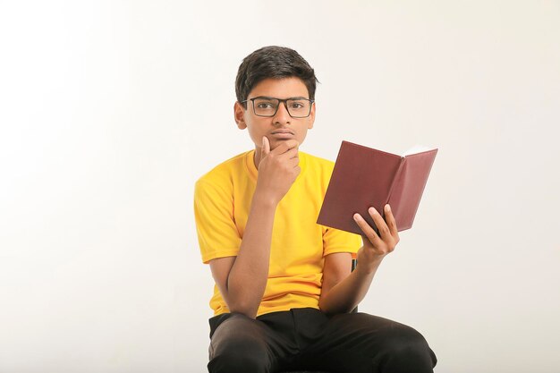 Indian boy holding diary in hand and thinking some idea on white background