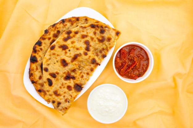 Indian Breakfast Dish Aloo Paratha Served With Curd And Pickle