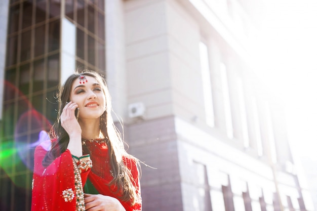 Indian bride talks on her Smartphone standing on the street