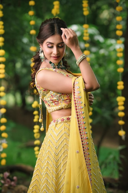 Photo indian bride wearing yellow dress and showing beautiful mehndi design and bangles